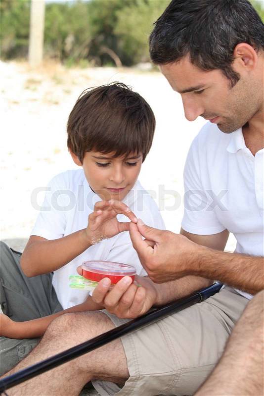 Father teaching his young son to fish, stock photo