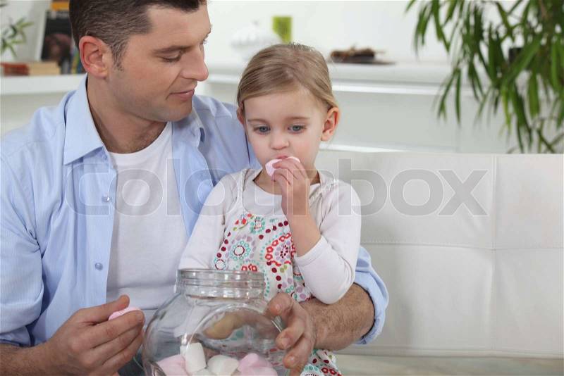 Dad and his daughter eating marshmallows, stock photo