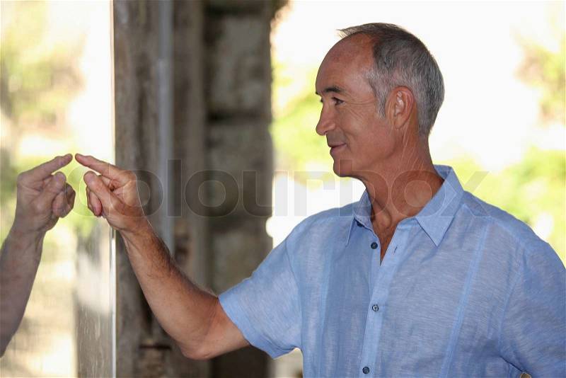 Senior man watching himself in a mirror, stock photo