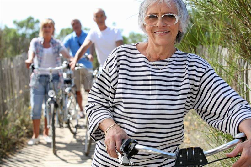 Older woman and friends on a bike ride, stock photo