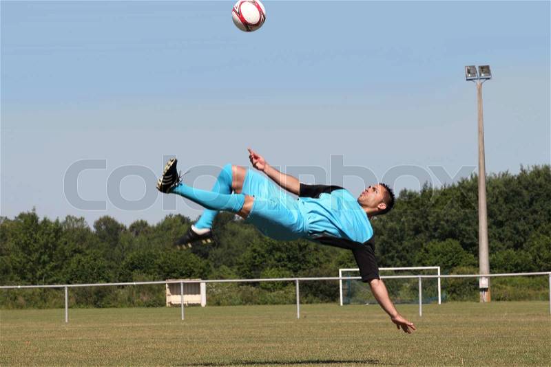 Footballer in mid-air back kick, stock photo