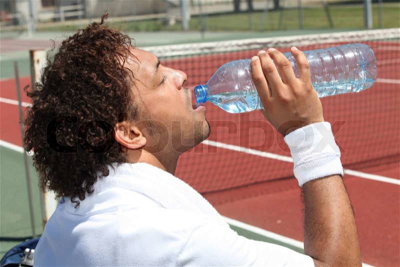 Tennis player drinking water, stock photo