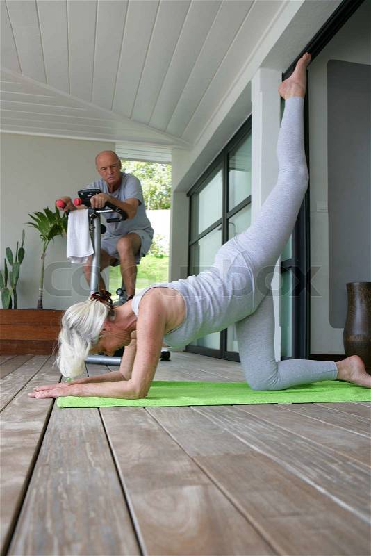 Senior people doing gymnastics at home, stock photo