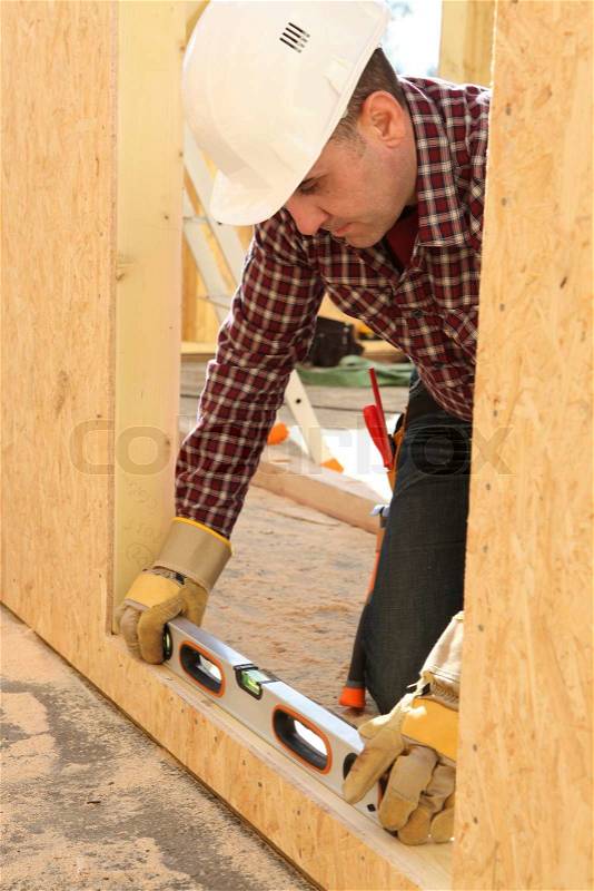 Woodworker using level spirit, stock photo