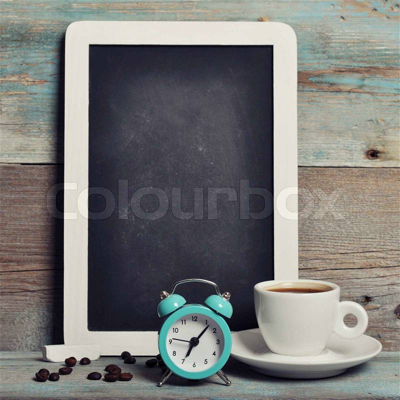 Cup of coffee with blackboard and alarm clock on vintage wooden background , stock photo