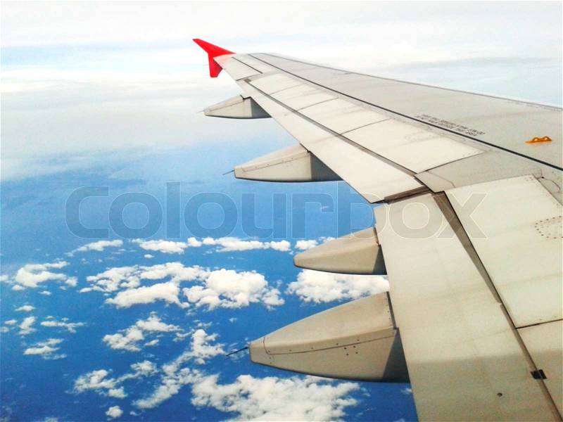 Looking through window aircraft in wing aerial view of landscape and sky, stock photo