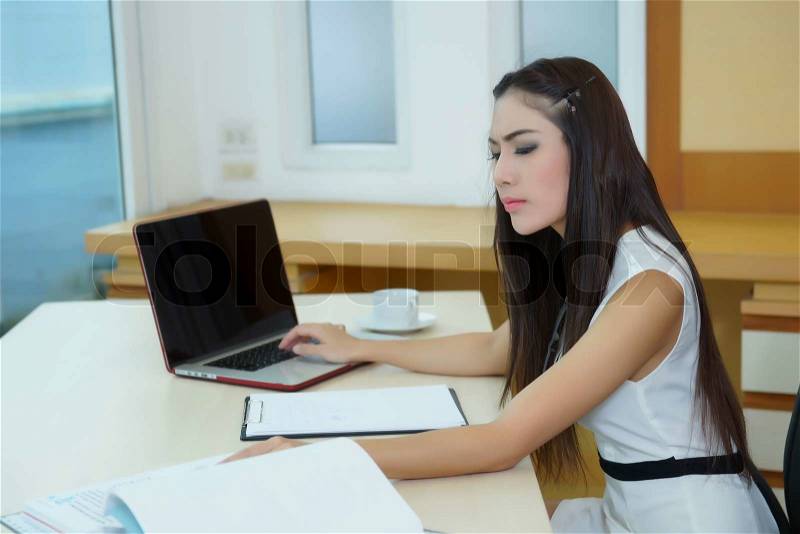 Young pretty business woman with notebook in the office, stock photo