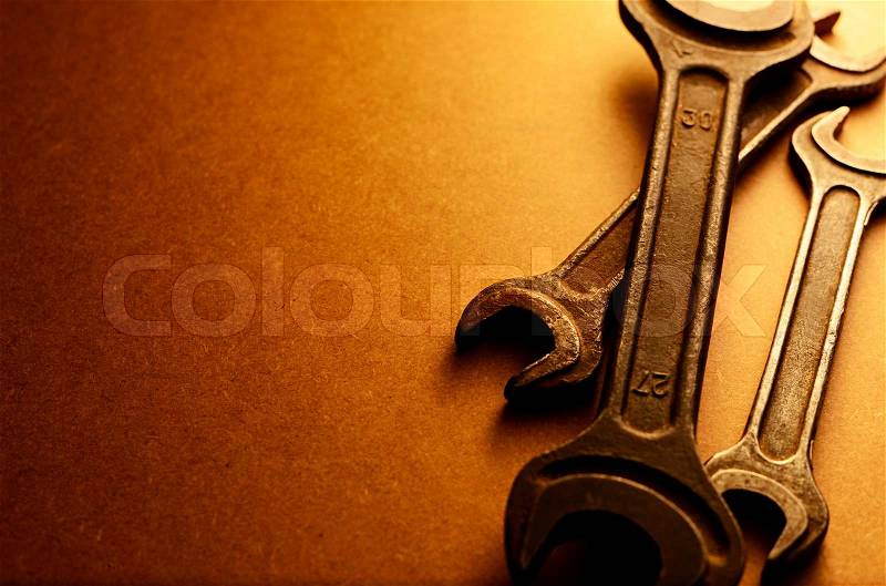 Set of three different sized spanners in a sepia toned image with a graduated background and copyspace, stock photo