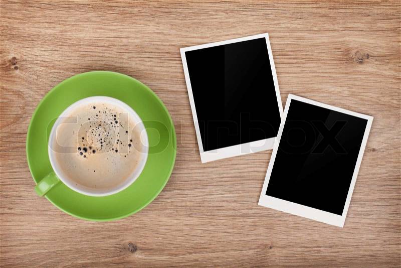 Cup of coffee and two photo frames on wooden table, stock photo