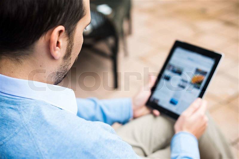 Elegant business multitasking multimedia man using devices at home, stock photo