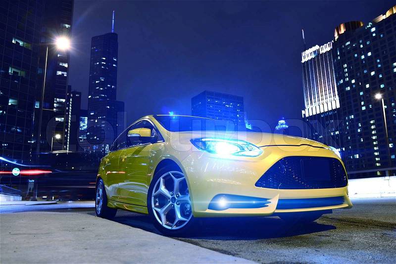 Performance Yellow Car in Downtown Chicago. Fast and Furious. Car at Night - Urban Theme. Performance Vehicles Photography Collection, stock photo