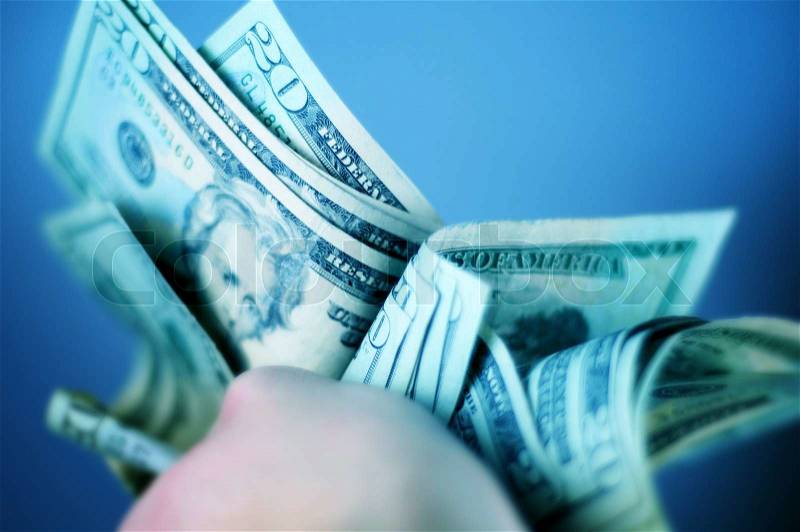 Hard Earned Dollars - Twenty American Dollar Bills. Cash in Hand. Bluish Color Theme, stock photo