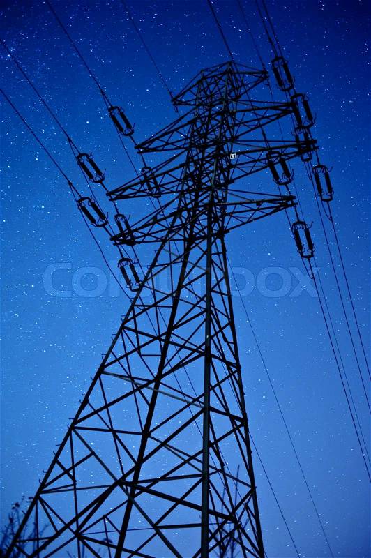 High Voltage Pole During NIght Hours. Clear NIght Sky with Many Stars. Vertical Long Exposure NIght Photography. HIgh Voltage Pylon, stock photo