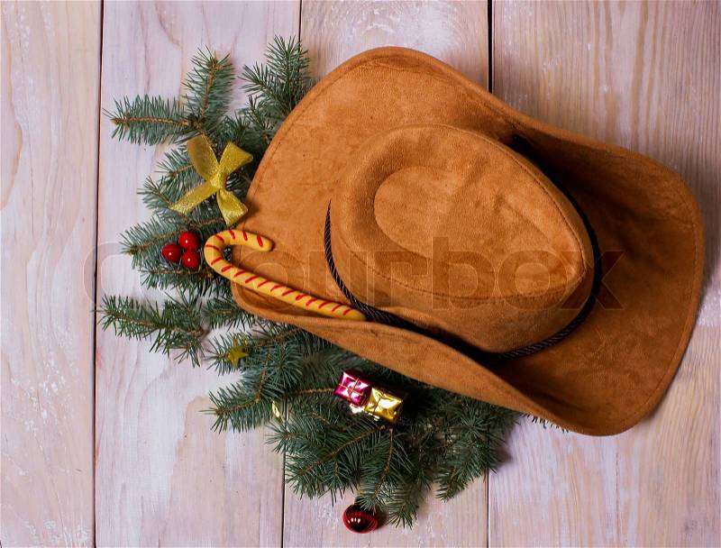 American western cowboy hat with Christmas decoration on wood background, stock photo