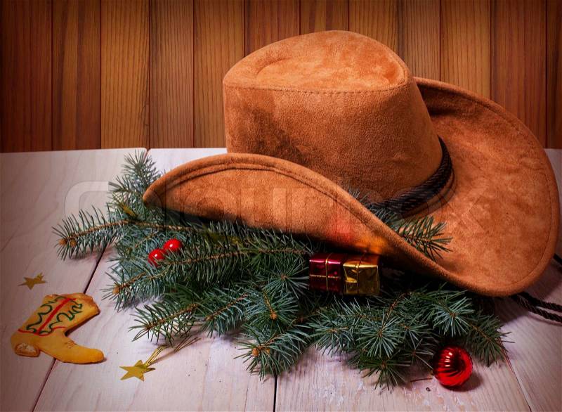 Cowboy western hat and Christmas decoration on wood background card, stock photo