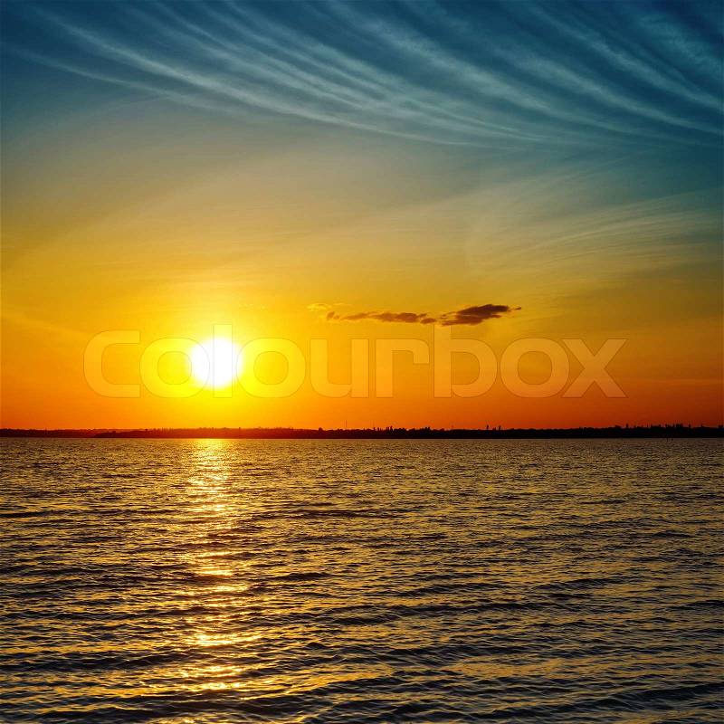 Summer orange sunset over darken sea, stock photo