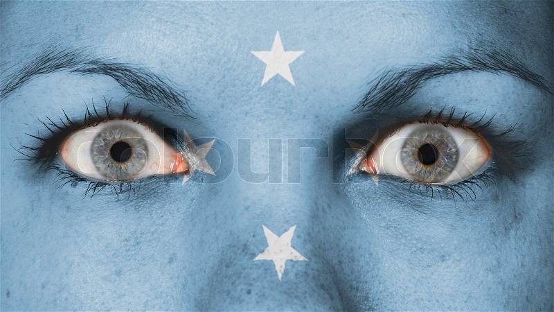 Close up of eyes. Painted face with flag of Micronesia, stock photo