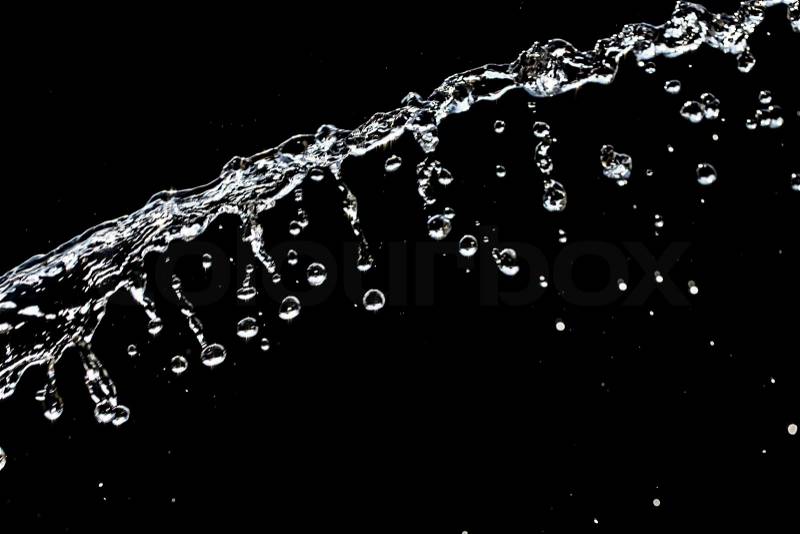 A jet of water on a black background, stock photo