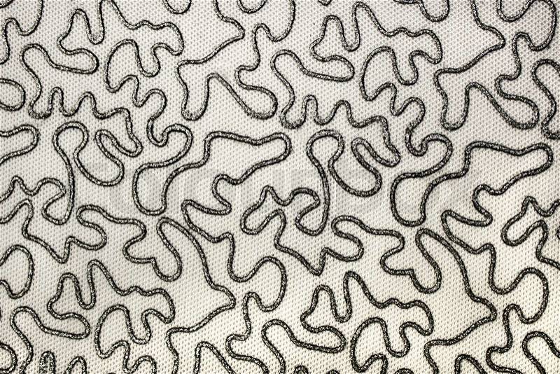 Sinuous shiny lines plotted on fabric, stock photo