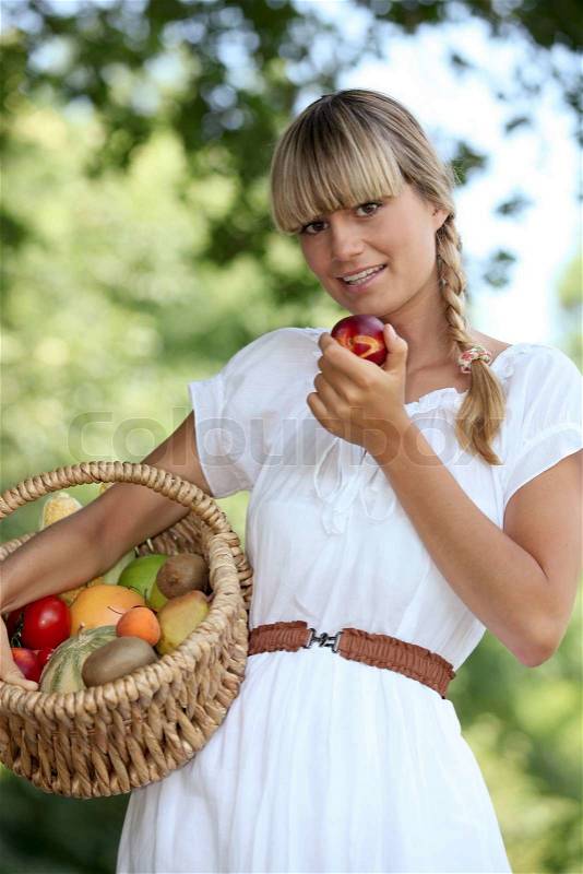 Blond woman carrying fruit basket, stock photo