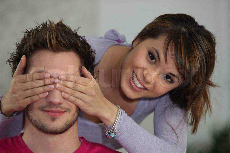 Woman covering boyfriend\'s eyes, stock photo