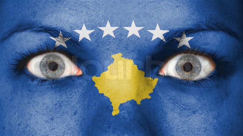 Close up of eyes. Painted face with flag of Kosovo, stock photo