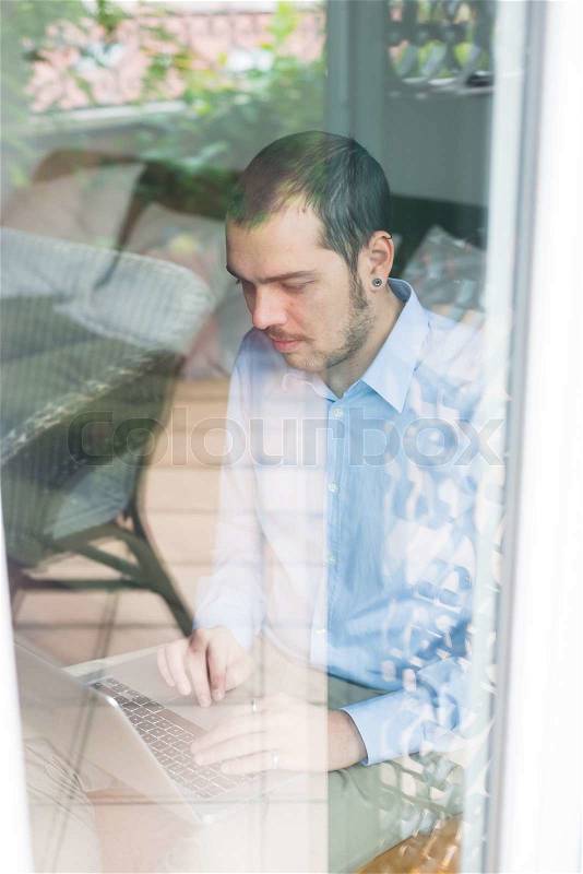 Elegant business multitasking multimedia man using notebook at home, stock photo