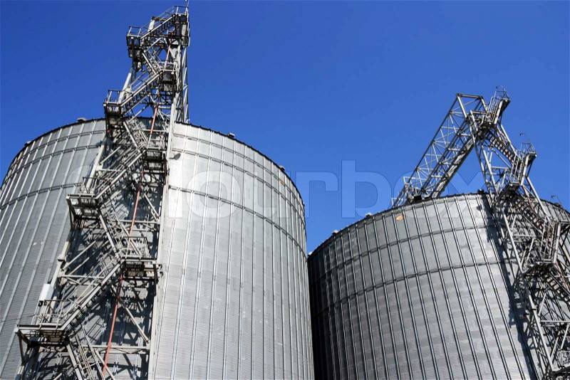 Grain storage place - metal containers against sky, stock photo