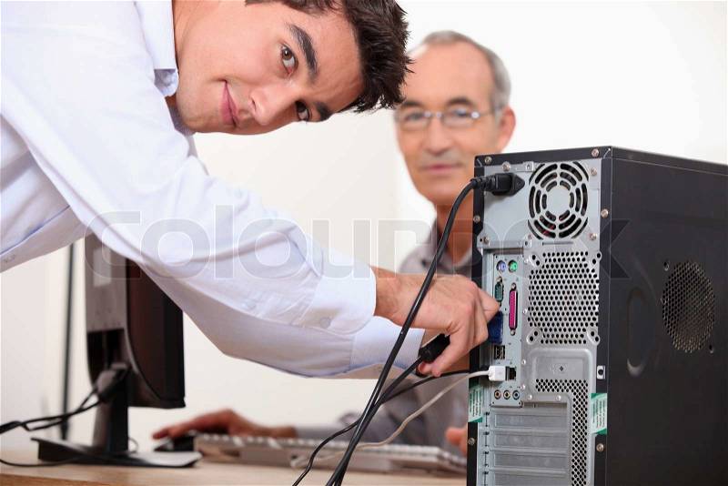 Computer technician repairing PC, stock photo