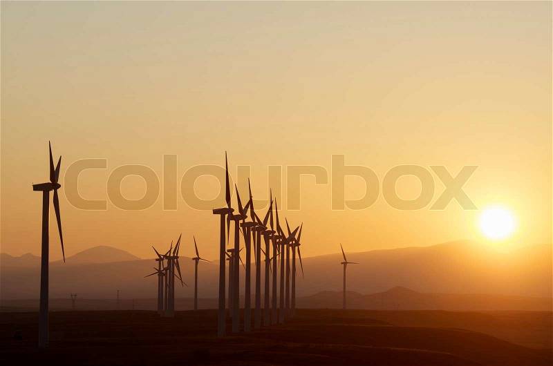 Aligned windmills for renowable electric production at sunset, Pozuelo de Aragon, Zaragoza, Aragon, Spain, stock photo