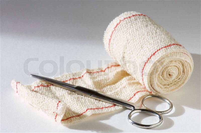 Medical scissors and bandages with white background, stock photo