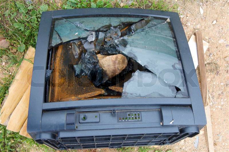 TV broken and abandoned in a dumpster, stock photo