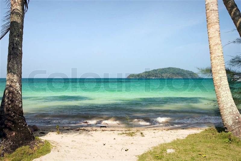 Small remote white sand beach on the Ko Mak island in Thailand with another island on the horizon, stock photo