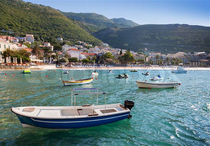 Fishing and pleasure boats float moored in Adriatic sea water. Petrovac town, Montenegro, stock photo