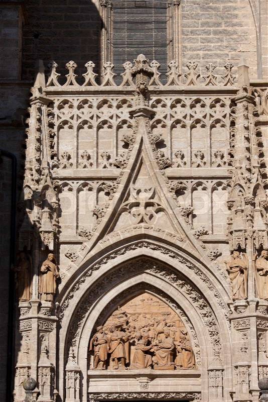 Tympanum with relief depicting the Adoration of the Three Wise Men and Gothic ornamentation on Puerta de Palos, doorway to the Cathedral of Seville in Spain, stock photo