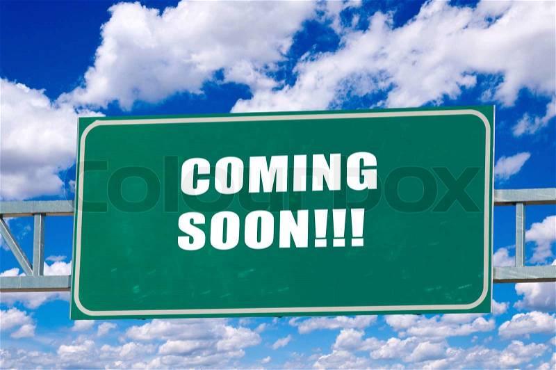 Coming soon sign on the green board with clouds in background, stock photo