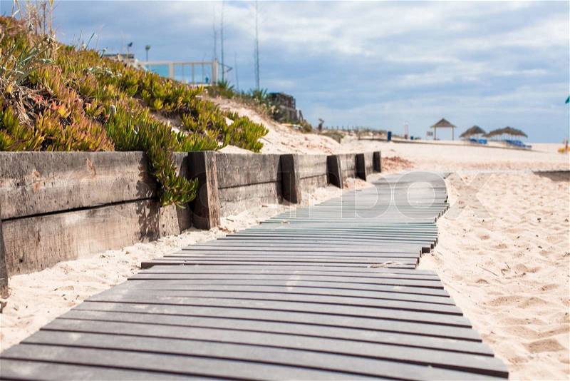 Close up view of a wood board walk in the beach pointing to the sea, stock photo