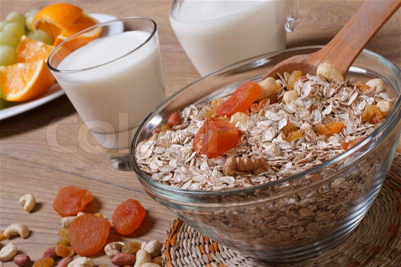 Oat flakes with dried fruit and milk and fresh fruit in the background, stock photo