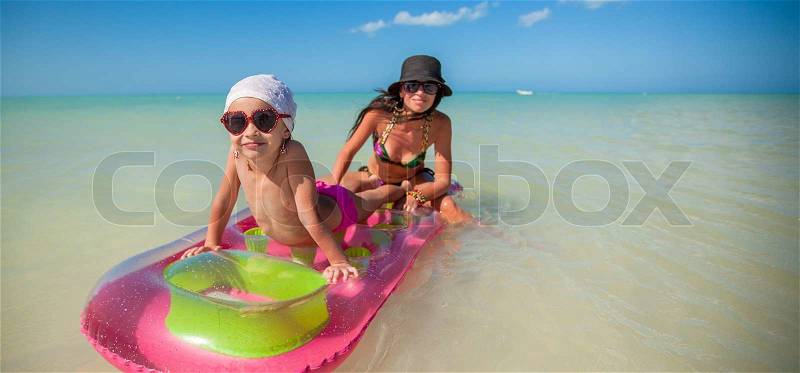 Little girl with young mother on an air mattress in the sea, stock photo