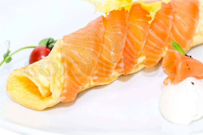 Scrambled eggs with cheese and salmon decorated with tomato on white background, stock photo