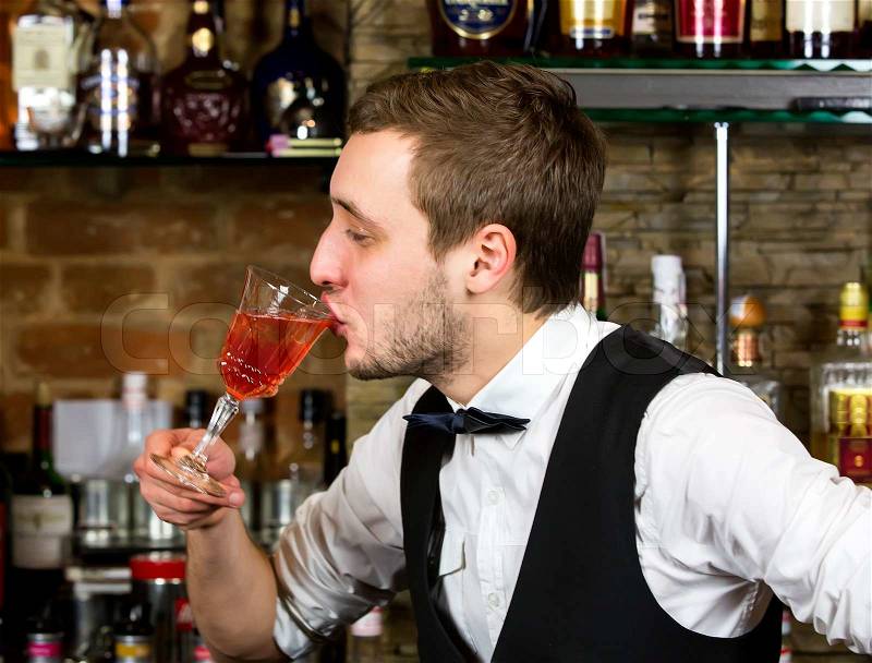 Multiple titlesyoung man working as a bartender in a nightclub bar, stock photo