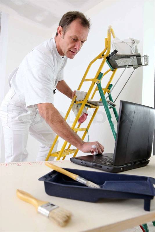 Painter taking quick break to reply to e-mail, stock photo