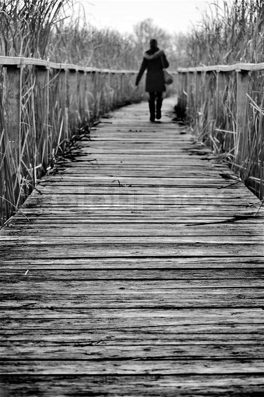 Girl walking on a path covered by wood, stock photo