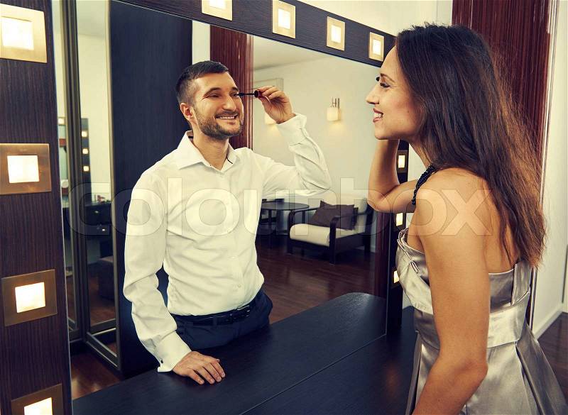 Smiley woman looking at man in the mirror, stock photo