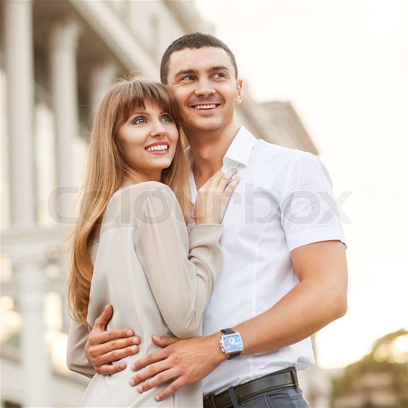 Young couple in love outdoor. She pressed against him, he is a gentle hugs her, stock photo
