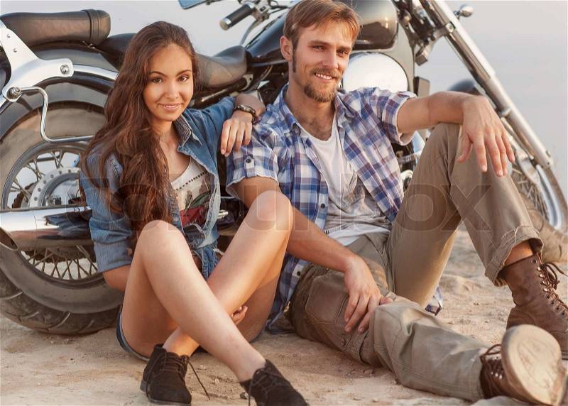 Two people and bike - fashion woman and man sitting by motorbike and resting. Adventure and vacations concept, stock photo