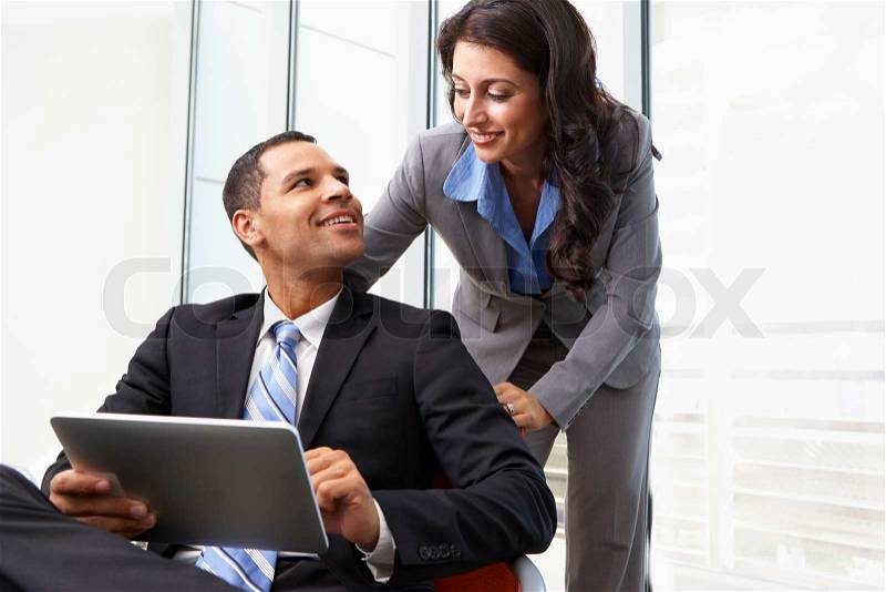 Businesspeople With Digital Tablet During Informal Meeting, stock photo