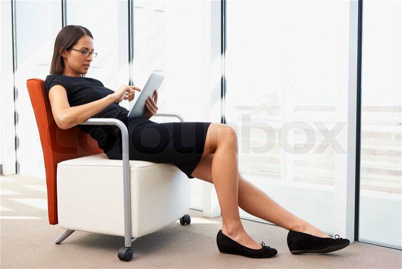 Businesswoman Relaxing With Digital Tablet During Break, stock photo