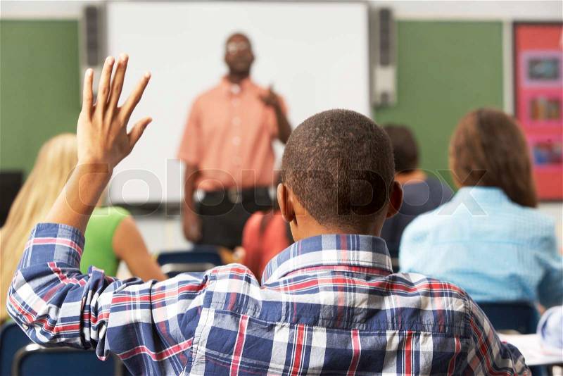 Male Pupil Raising Hand In Class, stock photo