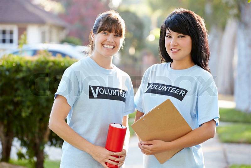 Portrait Of Two Female Charity Volunteers On Street, stock photo